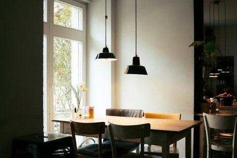 Cafe interior with tables and chairs near window.